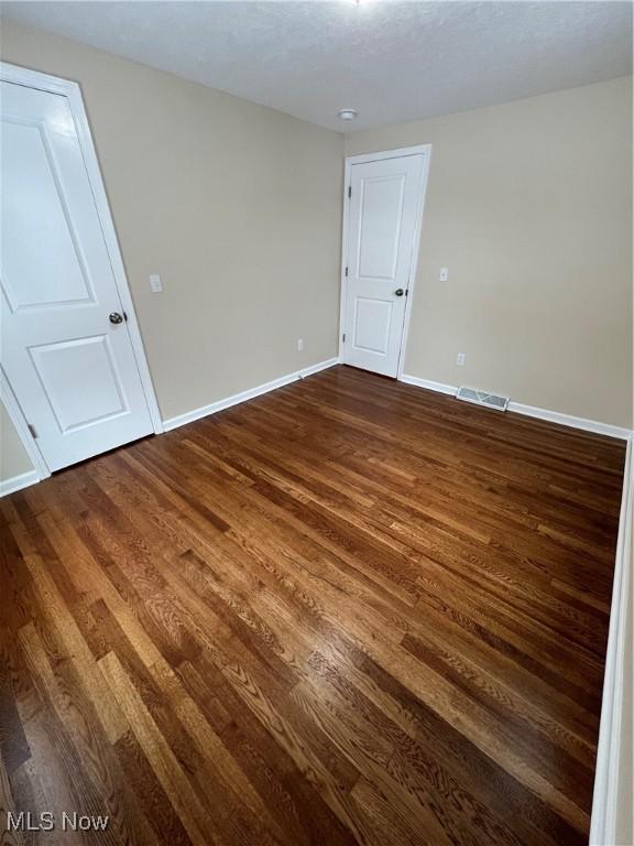 spare room featuring dark hardwood / wood-style floors