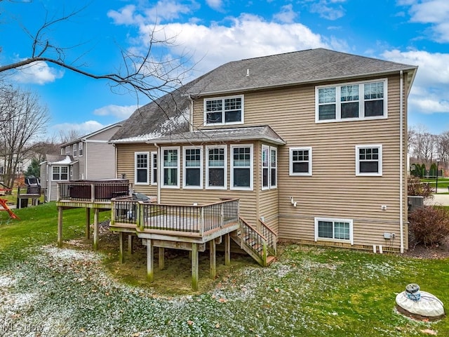 back of property with a lawn and a deck