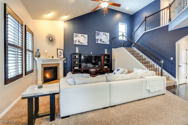 living room with carpet floors, high vaulted ceiling, and ceiling fan