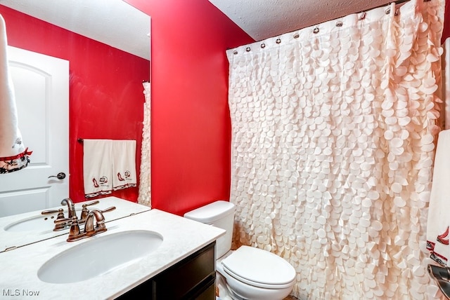 bathroom featuring vanity, toilet, and a textured ceiling