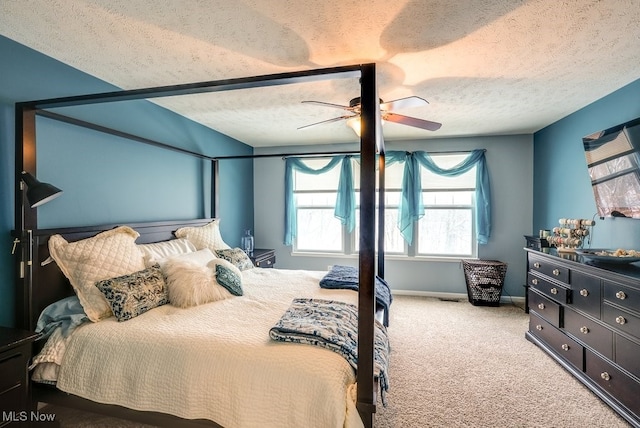 bedroom featuring ceiling fan, light colored carpet, and a textured ceiling