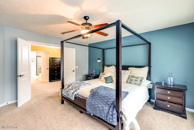 bedroom with ceiling fan, light colored carpet, and a textured ceiling