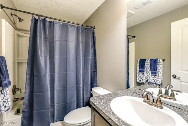 full bathroom with shower / tub combo with curtain, vanity, a textured ceiling, and toilet