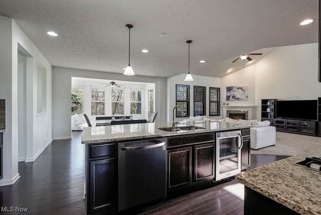 680 Morgan Trl, Aurora, OH 44202 - kitchen with dishwashing machine, a ceiling fan, a sink, open floor plan, and a glass covered fireplace