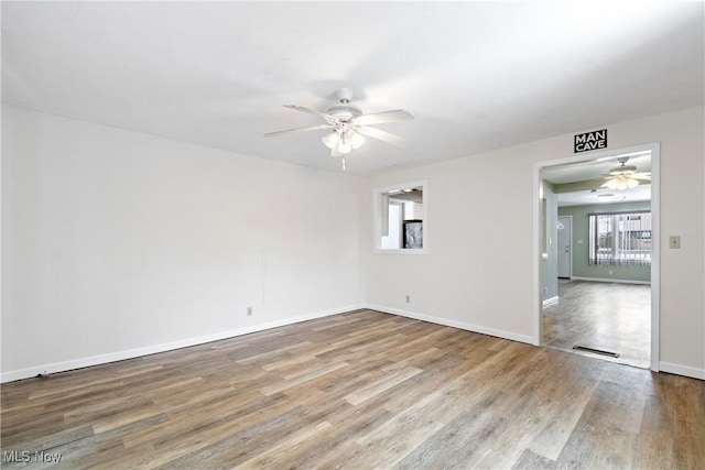 empty room with hardwood / wood-style floors and ceiling fan