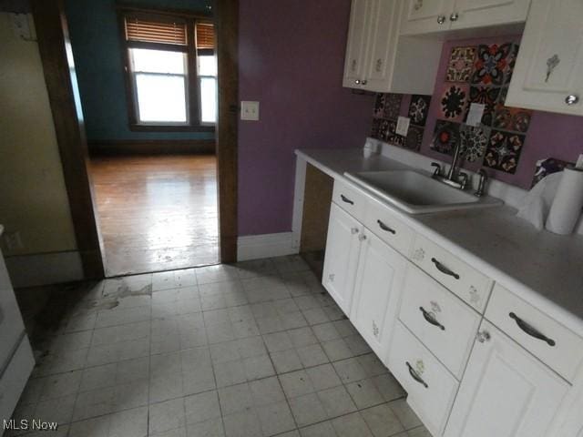 kitchen featuring white cabinetry and sink