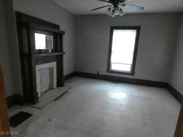 unfurnished living room featuring ceiling fan