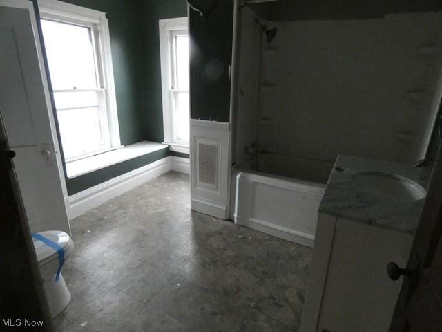 full bathroom with vanity, concrete floors, toilet, and bathing tub / shower combination