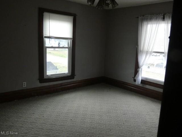 empty room featuring ceiling fan and light colored carpet