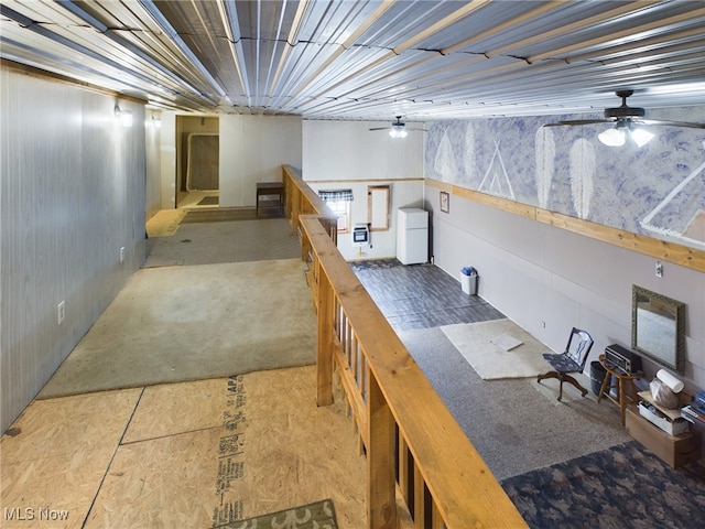 basement featuring white refrigerator and ceiling fan