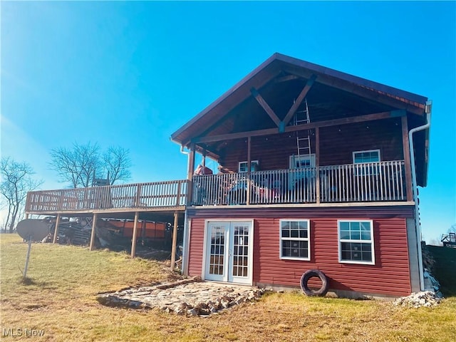 rear view of house featuring a lawn and a deck