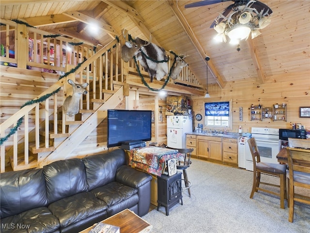 carpeted living room featuring beam ceiling, wood walls, high vaulted ceiling, and wooden ceiling