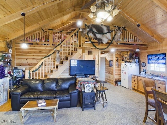 living room with a wood stove, wood walls, lofted ceiling with beams, and wooden ceiling