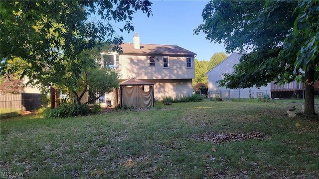 rear view of house featuring a yard