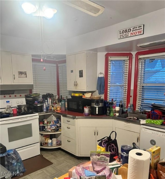 kitchen with white appliances, white cabinetry, and sink