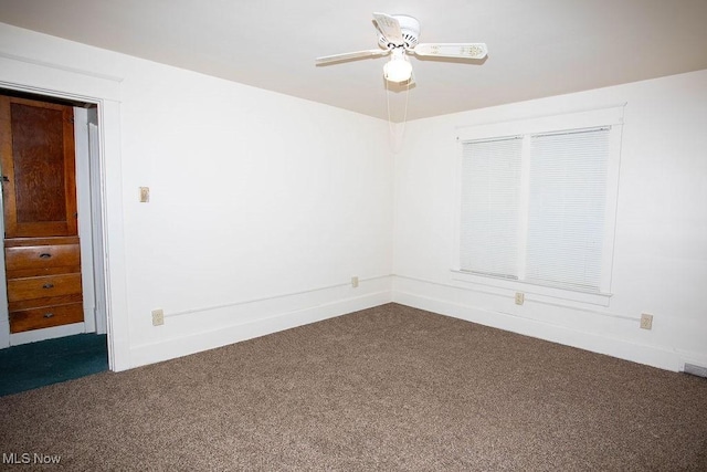 empty room with dark carpet and ceiling fan