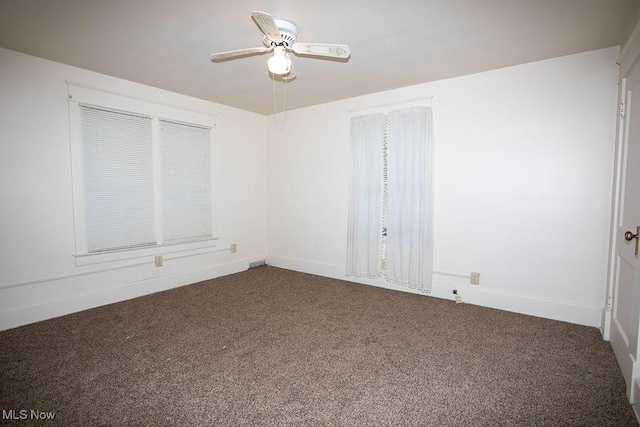 unfurnished room featuring ceiling fan and dark colored carpet