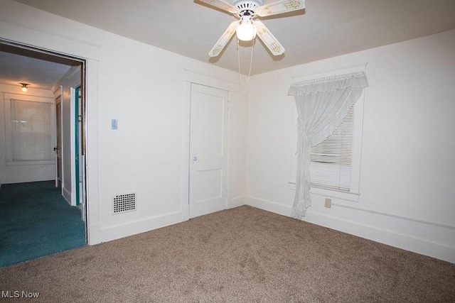 carpeted spare room featuring ceiling fan