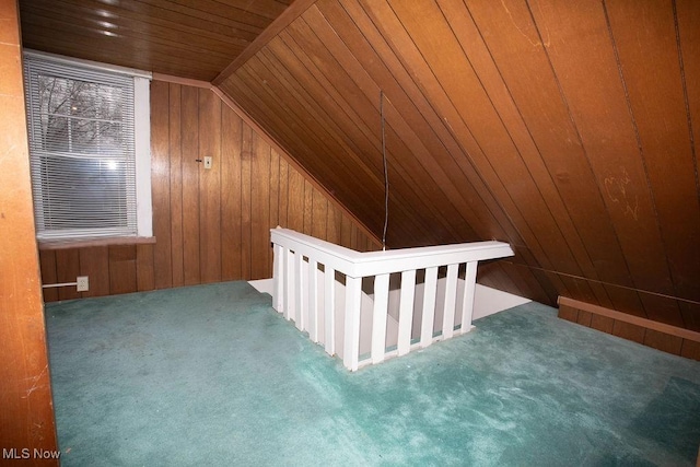 bonus room featuring wood walls, lofted ceiling, and dark colored carpet