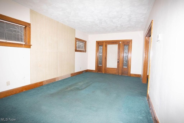 empty room with carpet flooring and a textured ceiling