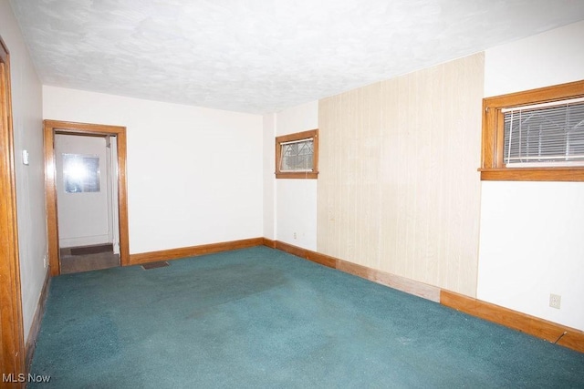 carpeted spare room featuring a textured ceiling