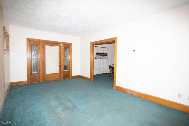 carpeted empty room featuring a textured ceiling