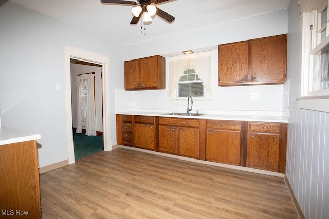 kitchen with ceiling fan, sink, and light hardwood / wood-style flooring