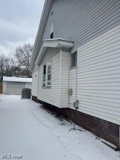 view of snowy exterior with an outbuilding