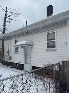 view of snow covered rear of property