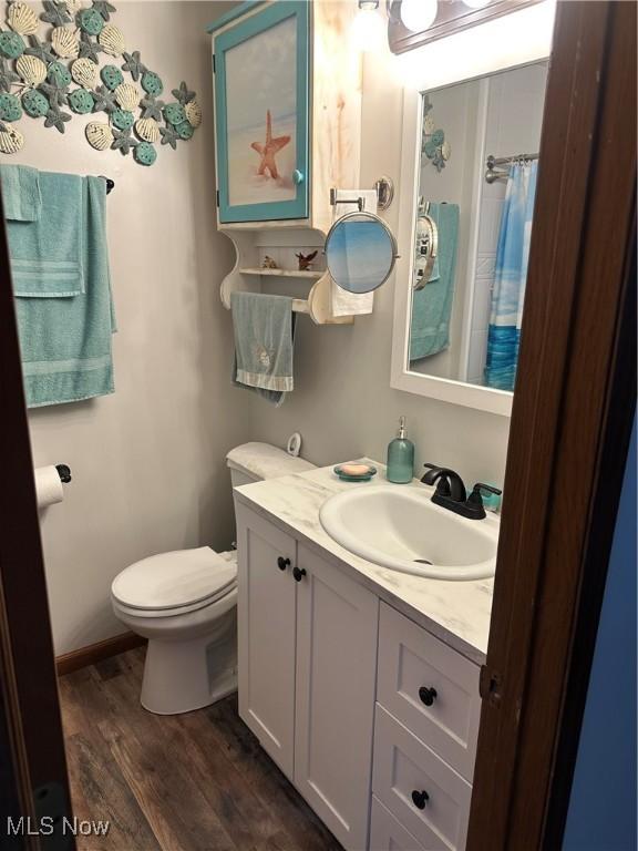 bathroom featuring vanity, toilet, and hardwood / wood-style floors