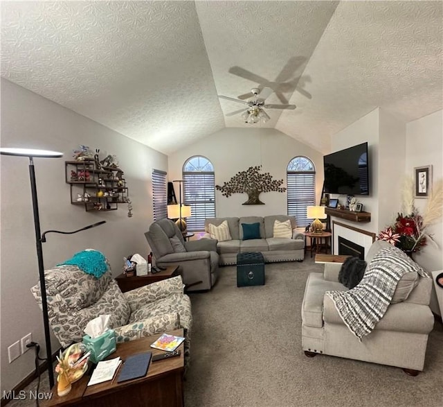 carpeted living room featuring ceiling fan, vaulted ceiling, and a textured ceiling