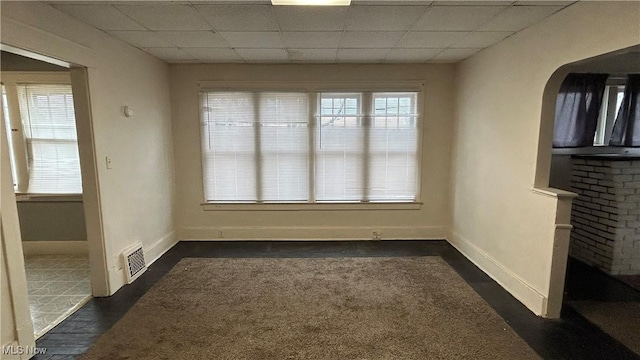 unfurnished dining area featuring a drop ceiling and plenty of natural light