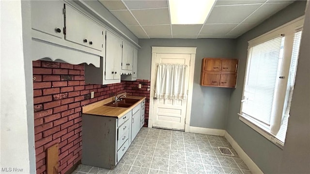 kitchen featuring a drop ceiling and sink