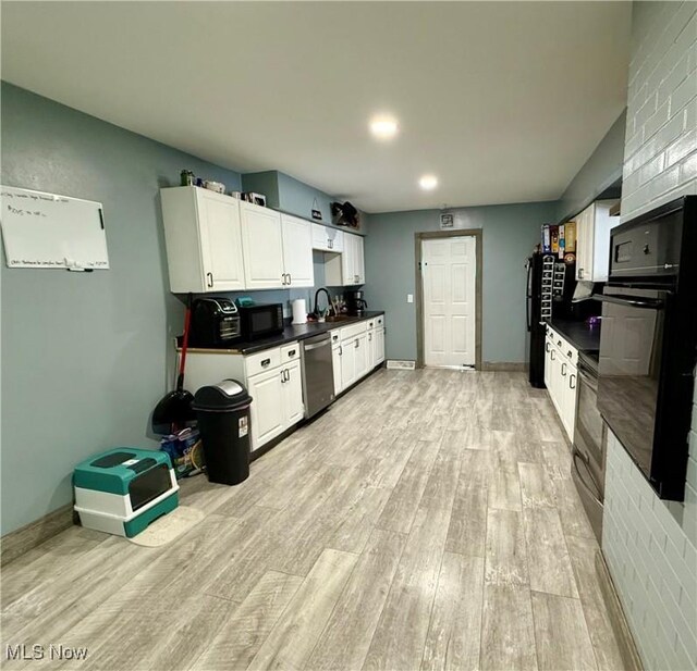 kitchen featuring sink, light hardwood / wood-style flooring, white cabinets, and black appliances