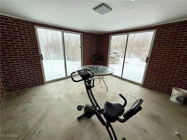 workout area featuring brick wall