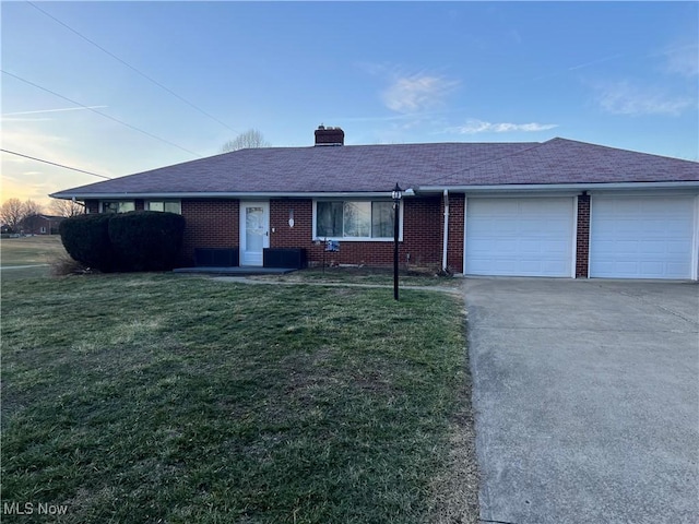 single story home featuring a garage and a lawn