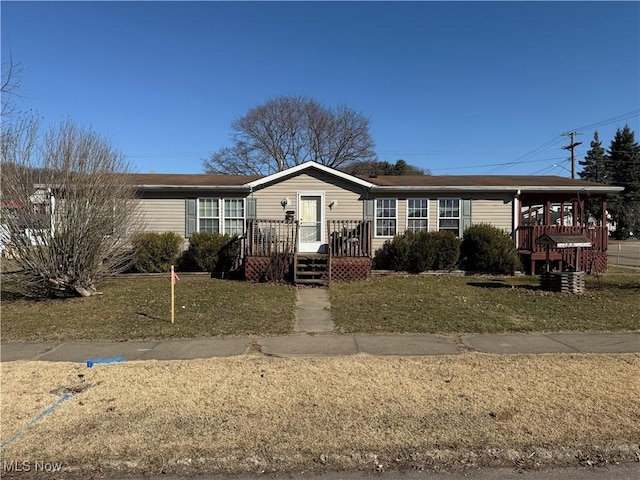 manufactured / mobile home featuring covered porch and a front lawn