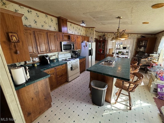 kitchen with a textured ceiling, white appliances, crown molding, wallpapered walls, and light floors