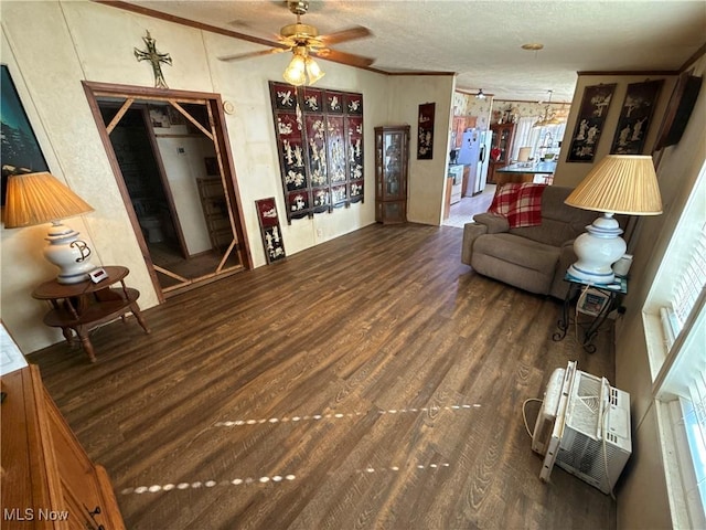 living area featuring ornamental molding, a textured ceiling, wood finished floors, a wall unit AC, and ceiling fan