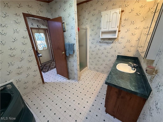 full bathroom featuring tile patterned floors, vanity, a shower stall, and wallpapered walls