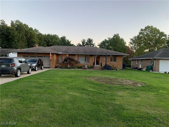 ranch-style home with a garage and a lawn