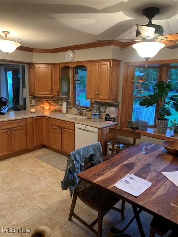 kitchen with tasteful backsplash, crown molding, sink, and white dishwasher