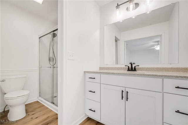 6301 Fiesta Ct, Lorain, OH 44053 - bathroom with vanity, a stall shower, wood finished floors, and ceiling fan