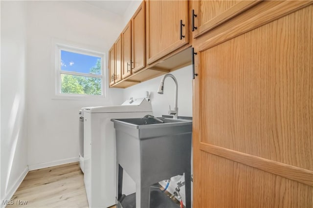 6301 Fiesta Ct, Lorain, OH 44053 - laundry area featuring cabinet space, washer and dryer, and light wood-type flooring