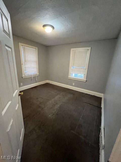 unfurnished room with a textured ceiling