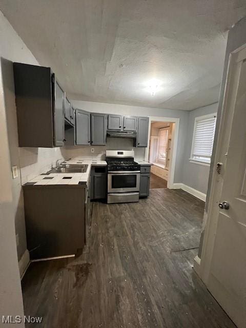 kitchen with gray cabinetry, dark hardwood / wood-style flooring, sink, and stainless steel stove