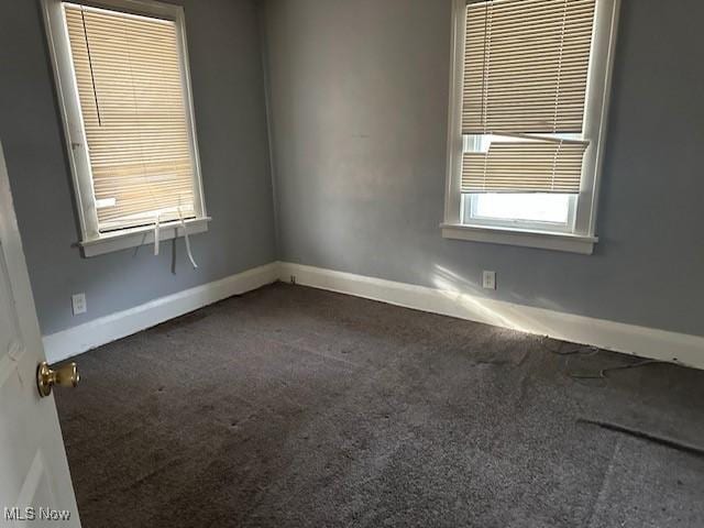 unfurnished room with dark colored carpet