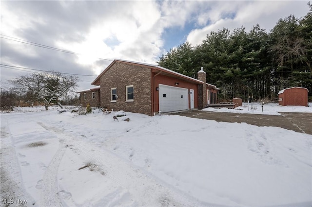 snow covered property with a garage