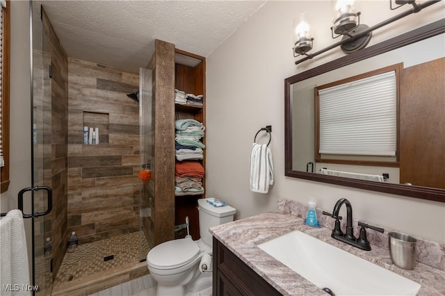 bathroom with vanity, an enclosed shower, a textured ceiling, and toilet