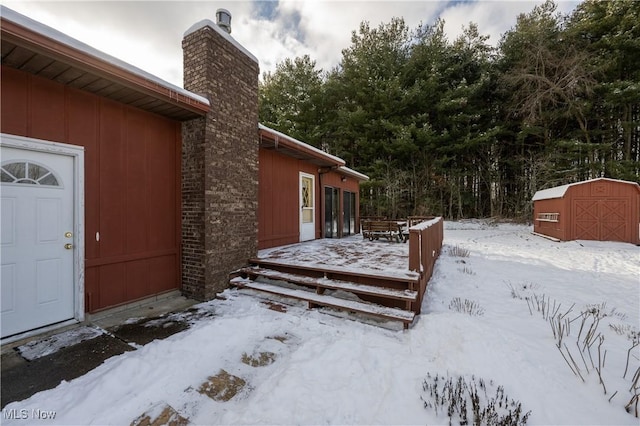 yard covered in snow featuring a storage shed